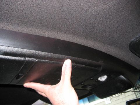 1991 Ford Bronco - Overhead console storage compartment being pressed by a hand.