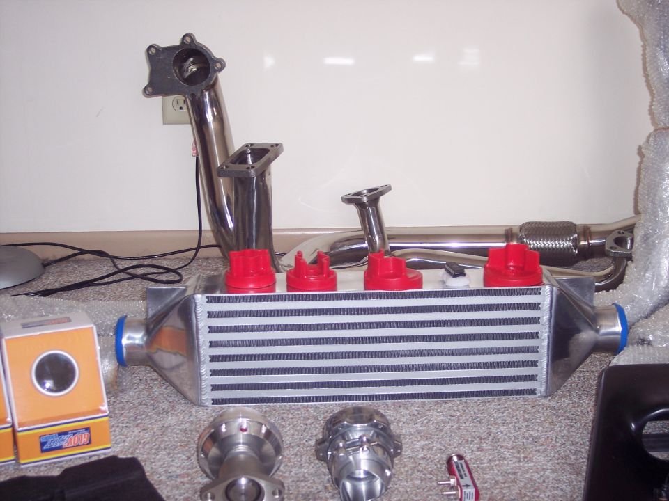 New turbo parts on carpet: front-mount intercooler, stainless downpipe, manifold and BOV