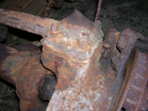 1979 Ford Bronco - Close-up view of severely corroded vehicle axle and suspension components, indicating extensive rust damage.