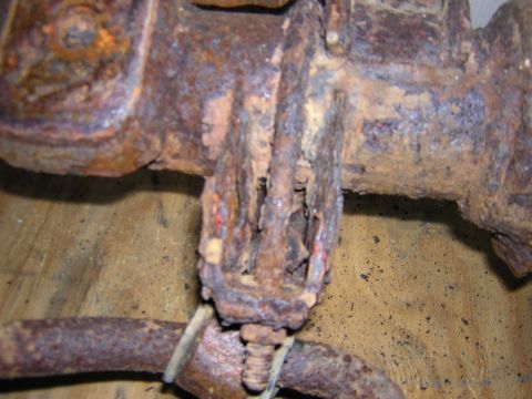 1979 Ford Bronco - Close-up of a heavily rusted metal bracket, likely a vehicle part, showing significant corrosion.