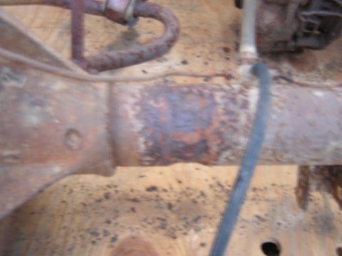 1979 Ford Bronco - Detail of a heavily rusted metal component, likely from a vehicle's undercarriage, showing significant corrosion.
