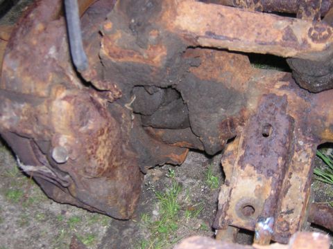 1979 Ford Bronco - Close-up of heavily corroded vehicle axle and suspension components, showing significant rust damage.