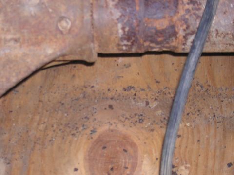 1979 Ford Bronco - Close-up view of a rusted metal component and a wooden surface with debris.