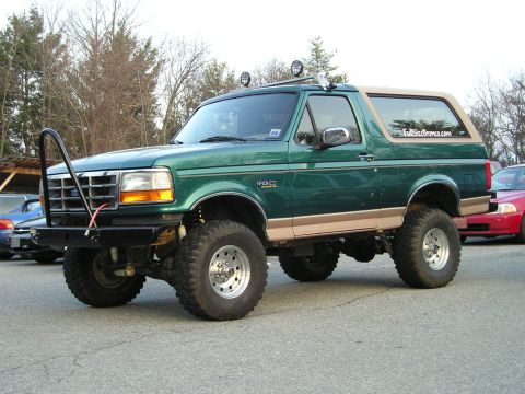 1996 Ford Bronco - Green 1996 Ford Bronco with custom bumper and lift kit parked outdoors.