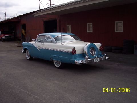 1960 Ford Falcon - Rear view of a classic two-tone blue and white sedan with a continental kit.