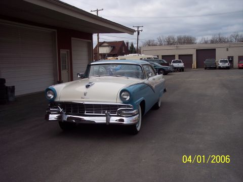 1960 Ford Falcon - This two-tone blue and white 1956 Ford Fairlane Crown Victoria is parked in front of a garage.