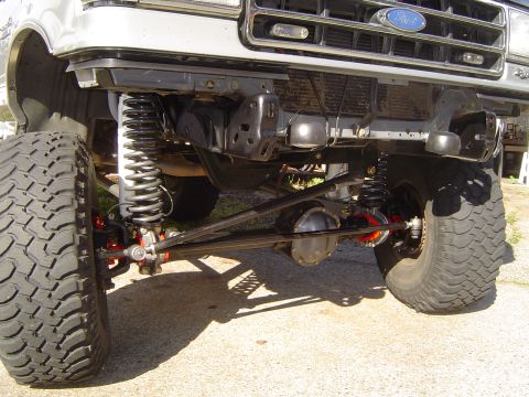 1989 Ford Bronco - Close-up view of the heavy-duty front axle and suspension system on a modified truck.