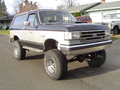 1989 Ford Bronco - This lifted Ford Bronco has a two-tone paint scheme and is equipped with large off-road tires.