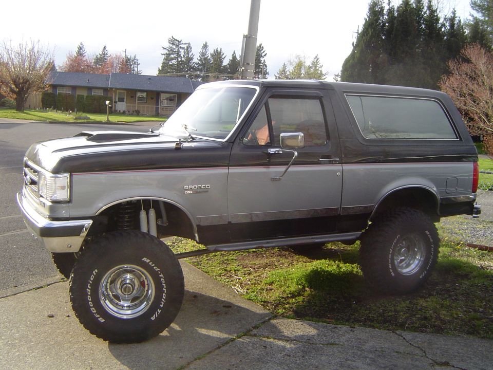 Lifted black and silver Ford Bronco XLT on BFGoodrich Mud-Terrain tires, side view