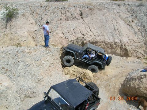 1985 Ford Bronco - Off-road vehicles navigate a challenging rocky terrain on a sunny day.