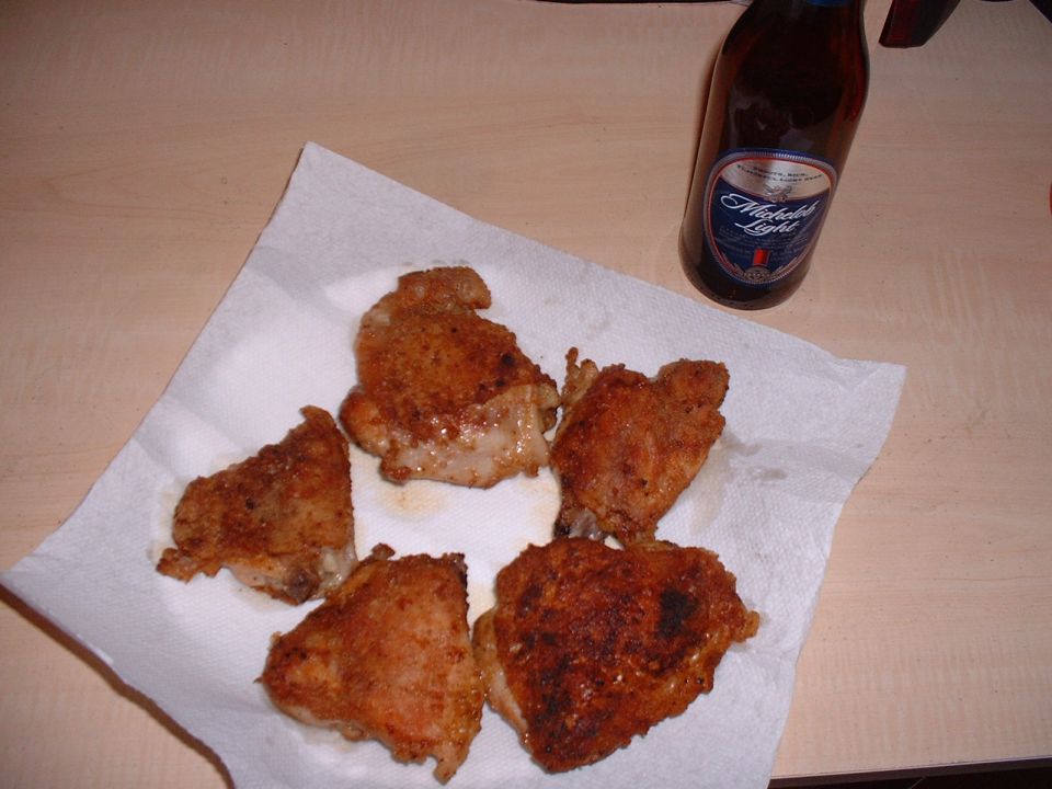 Cooking some chicken, drinking a beer.
