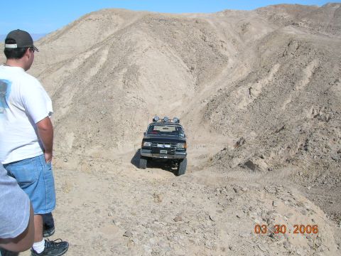 1985 Ford Bronco - A 1985 Ford Bronco navigates a challenging off-road course in a desert environment.