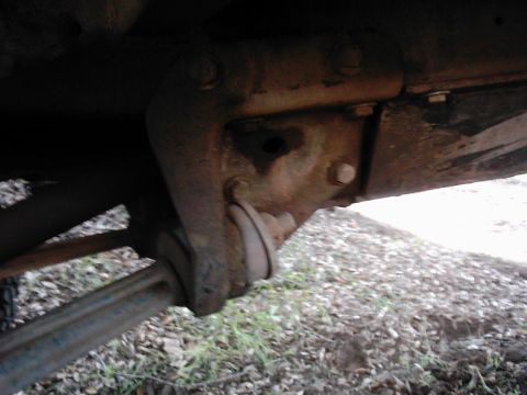 1978 Ford Bronco - Underside view of a vehicle's suspension system, showing a metal bracket and linkage.