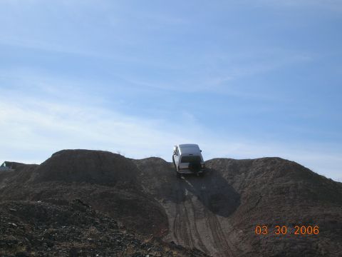 1985 Ford Bronco - A silver SUV navigates a steep dirt incline under a clear blue sky, with a date stamp of 03 30 2006 visible.