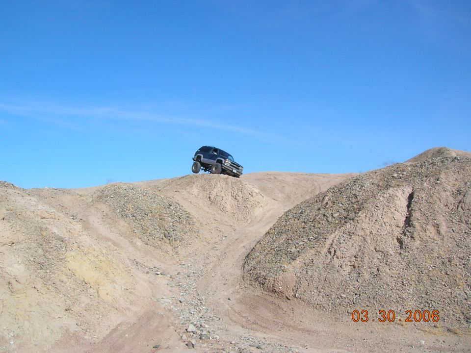 SUV on a dirt hill under a clear blue sky. Date stamp reads 03.30.2006