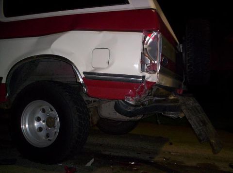 1989 Ford Bronco - Rear view of a damaged 1989 Ford Bronco showing significant collision impact.