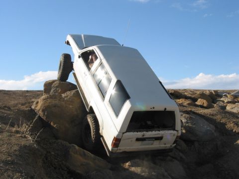 1981 Ford Bronco - White 1984 Toyota 4Runner navigates a rocky off-road course.