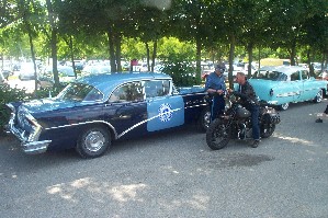 1991 Ford Crown Victoria - A 1956 Buick Century sedan is parked next to a motorcycle and another light blue car.