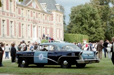 1991 Ford Crown Victoria - This vintage Massachusetts State Police car is parked on a lawn in front of a large building.