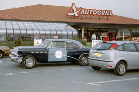 1991 Ford Crown Victoria - A 1956 Buick Century police car is parked next to a modern Ford Focus at an Autogrill.