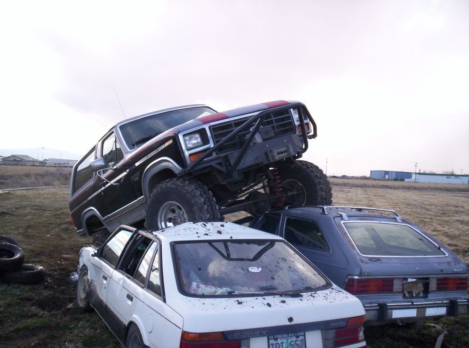Modified dark blue SUV with red stripe on top of a white sedan and a blue hatchback