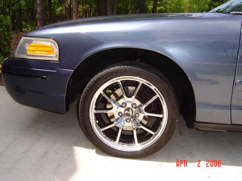 1998 Ford Crown Victoria - Front corner view of a 1998 Ford Crown Victoria showing the headlight and wheel.