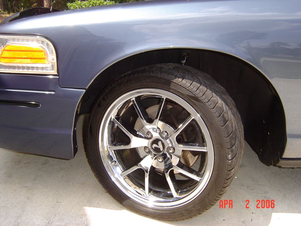 Blue 1998 Ford Crown Victoria front fender and chrome wheel