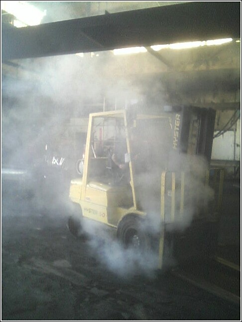 Yellow Hyster forklift doing a burnout, emitting smoke