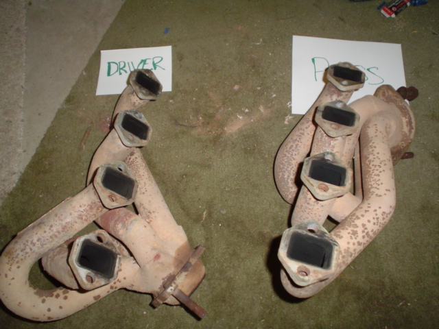 Pair of V8 cast-iron exhaust manifolds labeled DRIVER and PASS with white high-heat paint