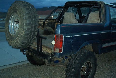 1986 Ford Bronco - This SUV, likely from the 1980s, features a rear-mounted spare tire and a lifted suspension.