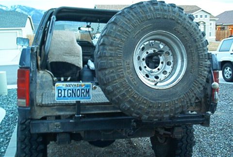 1986 Ford Bronco - This Ford Bronco, likely from the early 1980s, is seen from the rear with a large spare tire and a custom bumper.