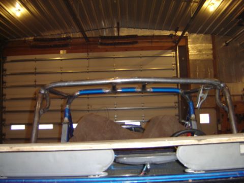 1992 Ford Bronco - Custom roll cage structure with blue padding, seen inside a garage with a large overhead door.