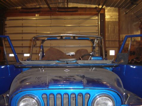 1992 Ford Bronco - Front view of a blue Jeep Wrangler with its doors open and a roll cage visible.