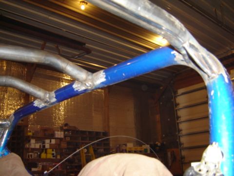 1992 Ford Bronco - Close-up of a custom roll cage structure with blue painted sections and metal tubing.