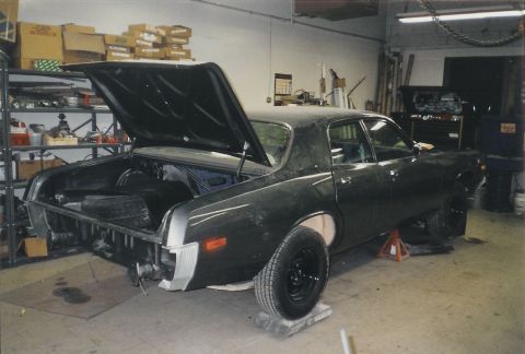 1978 Dodge Monaco - A dark green sedan sits in a garage with its trunk and hood open, undergoing restoration.