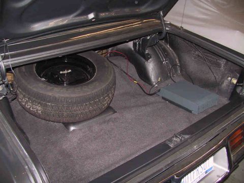 1978 Dodge Monaco - The trunk of a car contains a spare tire and an aftermarket amplifier.