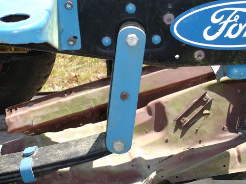 1989 Ford Bronco - Close-up of a Ford emblem on a vehicle's frame, showing mechanical components.