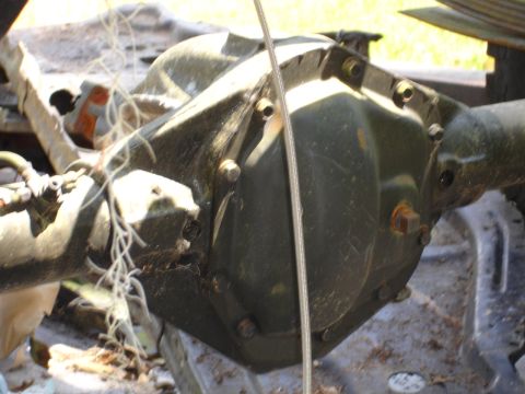 1989 Ford Bronco - Close-up view of a vehicle's rear axle differential, showing mechanical components and some debris.