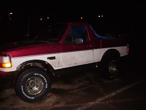 2000 Chevrolet Tahoe - A two-tone red and white pickup truck is parked outdoors at night, showing its BFGoodrich All-Terrain T/A tires.