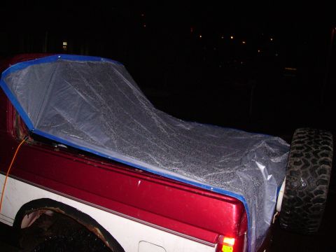 2000 Chevrolet Tahoe - A truck bed is covered with a tarp, with a spare tire mounted at the rear.