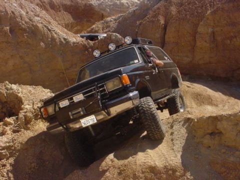 1988 Ford Bronco - 1988 Ford Bronco navigating a steep, sandy off-road trail.