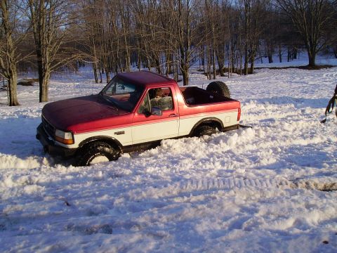 2000 Chevrolet Tahoe - Pickup truck is stuck in a snowy field with trees in the background.