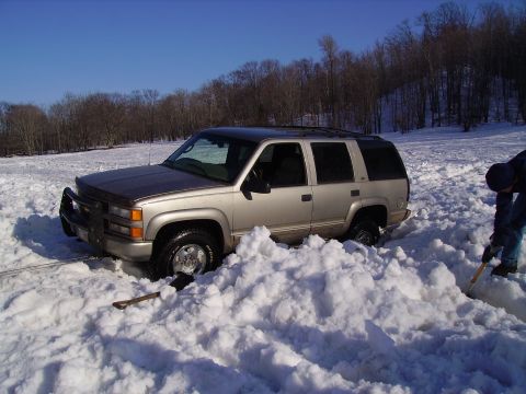 2000 Chevrolet Tahoe - Chevrolet Tahoe buried in snow, requiring manual digging to free it.