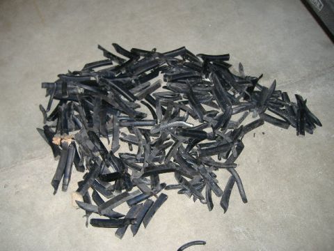 1979 Ford Bronco - A large quantity of black rubber trim pieces are scattered on a gray concrete surface.
