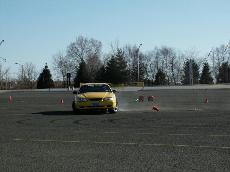 Yellow sedan drifting on a track with cones