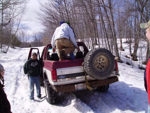 2000 Chevrolet Tahoe - Ford pickup truck in snowy woods with people loading into the bed.