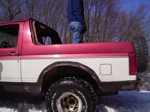2000 Chevrolet Tahoe - This two-door SUV, possibly a Ford Bronco, is seen from the rear with a spare tire mounted externally.