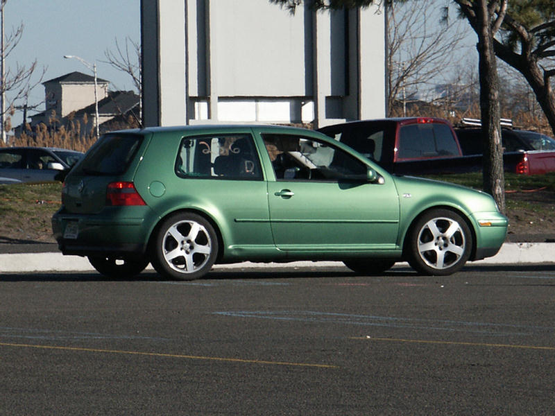 Green hatchback car with five-spoke wheels, seen from the side