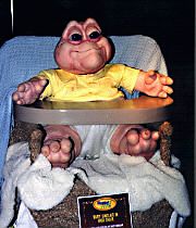 1992 Ford Probe - This photo shows Baby Sinclair from the TV show Dinosaurs, seated in a high chair with a watermark at the bottom.