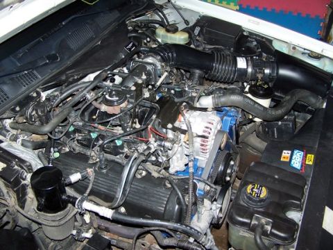 2000 Ford Crown Victoria - Close-up view of a car's engine compartment, showing various mechanical components and wiring.